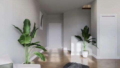 A living room with a white couch and two green plants.