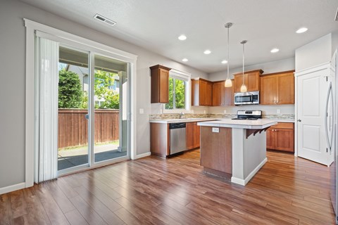 A kitchen with wooden cabinets and a white island.