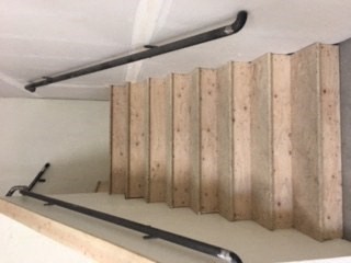 a wooden wall with metal railings on a staircase