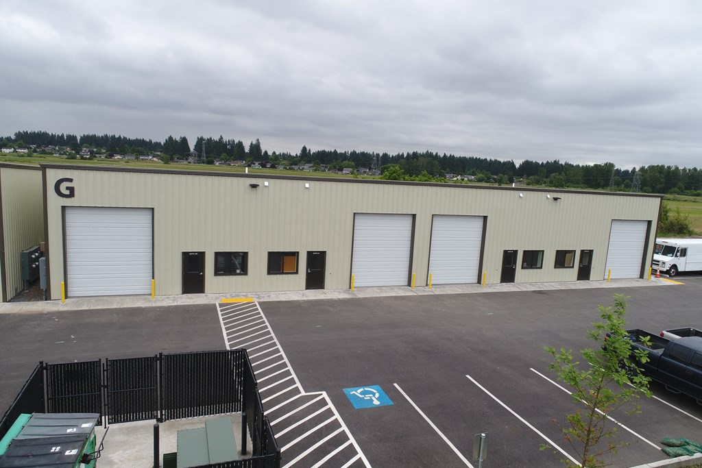 a large building with three garage doors and a parking lot
