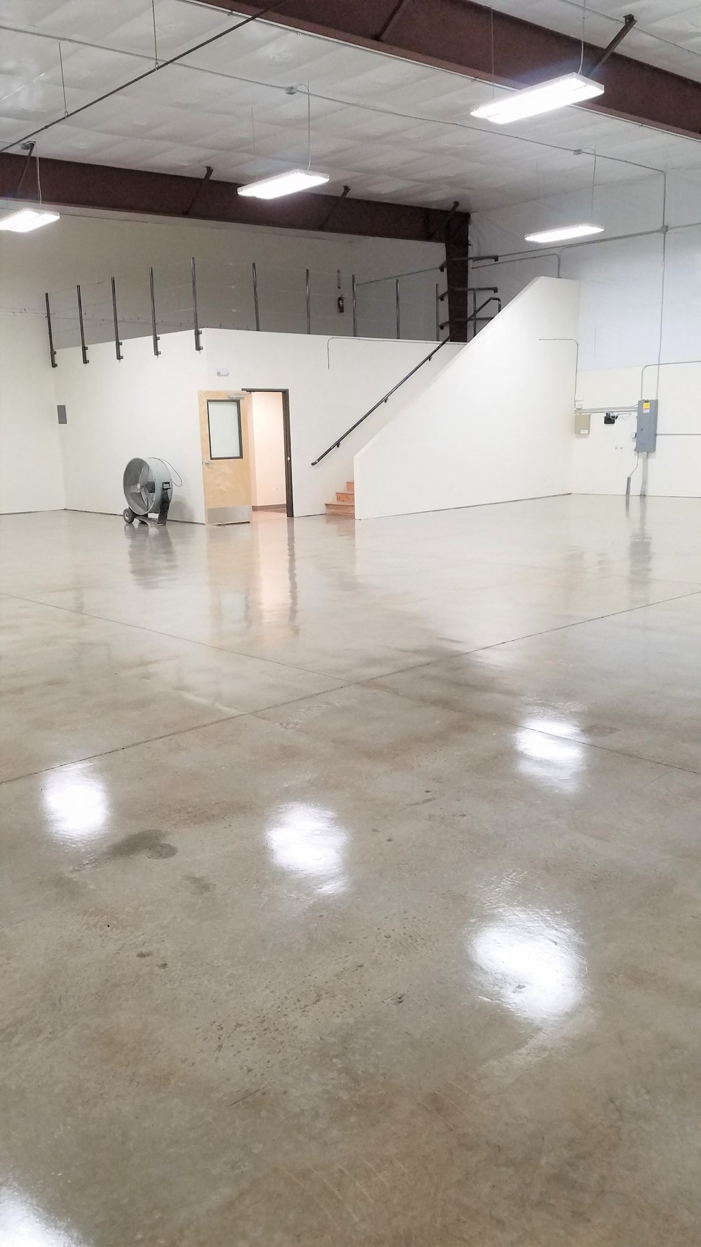 a large room with white walls and a concrete floor
