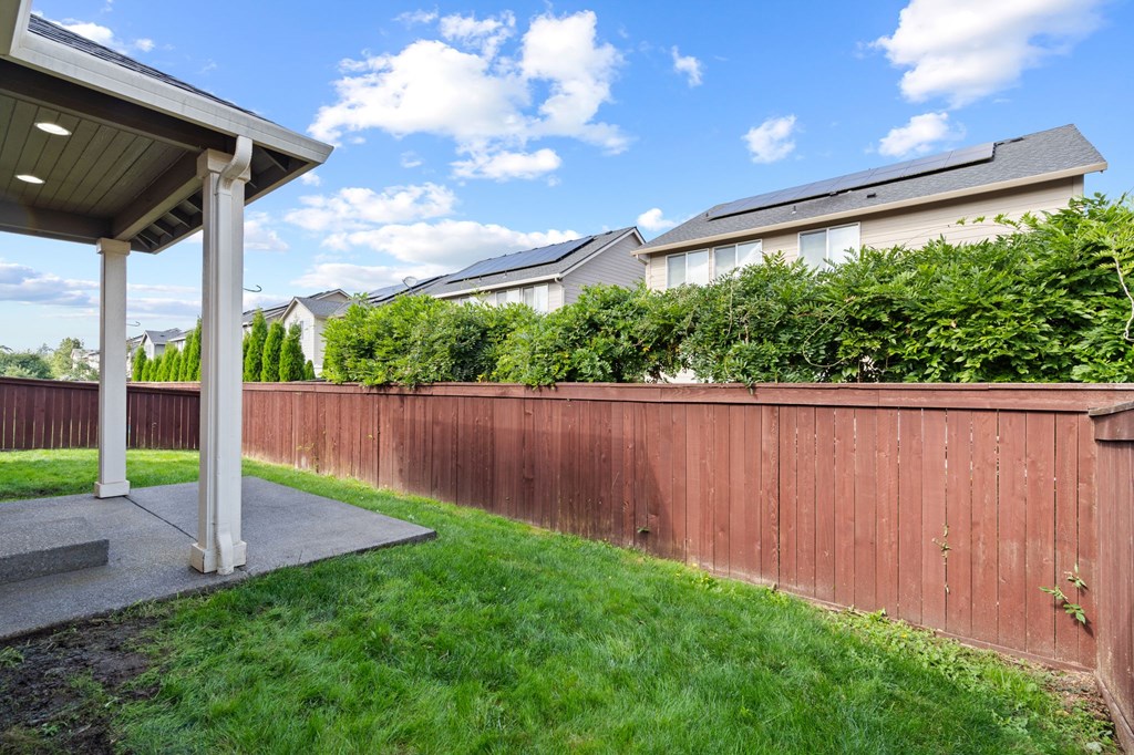 A wooden fence with a small garden in front of a house.