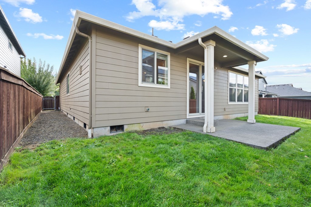 A small house with a grey roof and a porch.