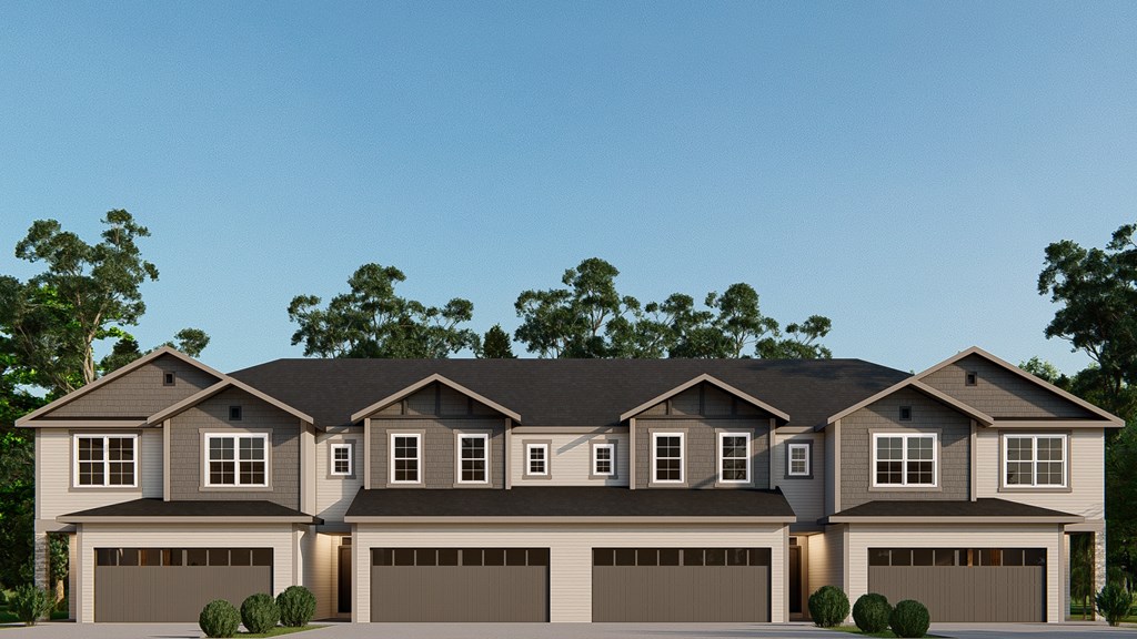 A modern house with a grey roof and brown garage doors.