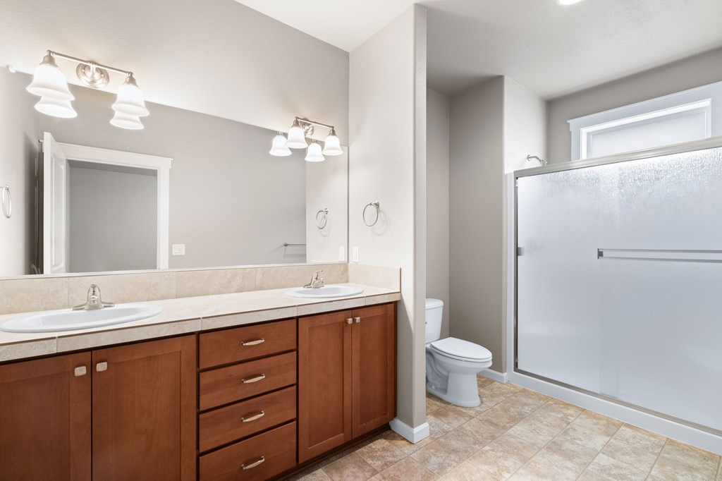 A bathroom with a sink, toilet, and shower.