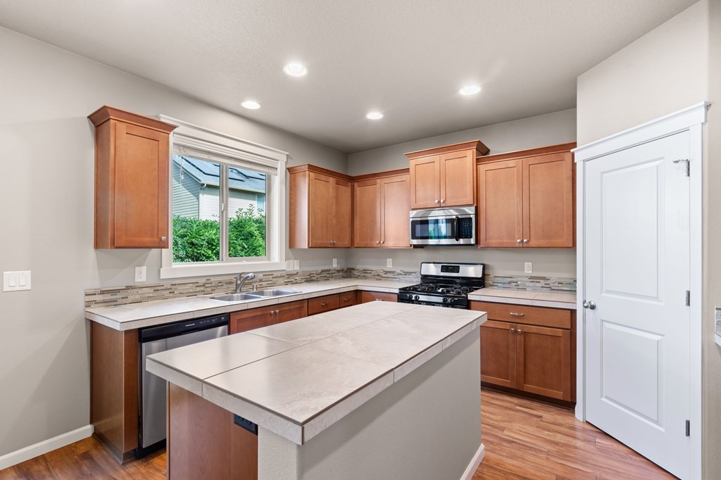 A kitchen with wooden cabinets and a stainless steel island.