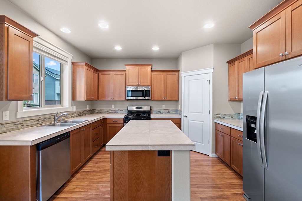 A kitchen with wooden cabinets and stainless steel appliances.