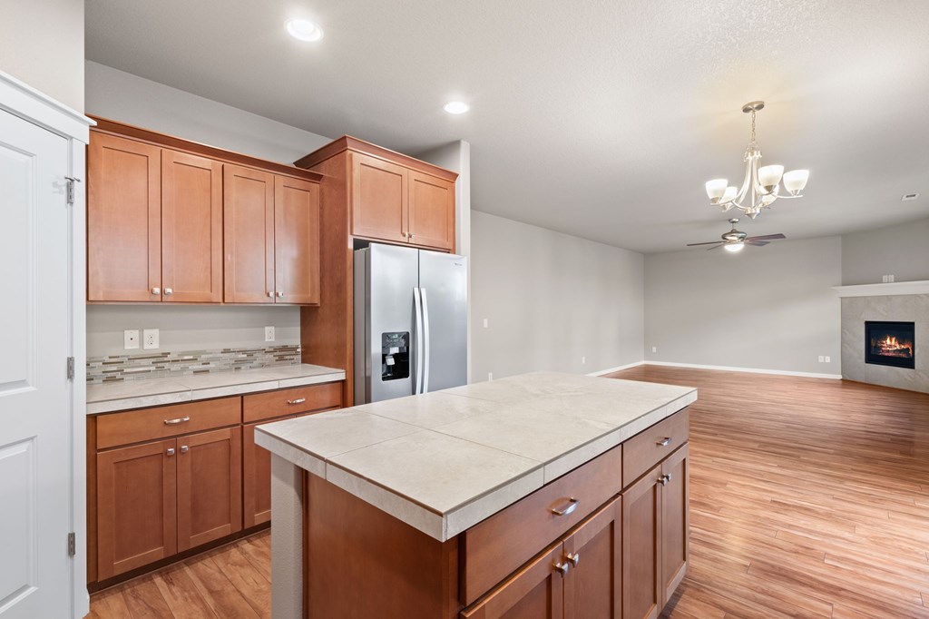 A kitchen with wooden cabinets and a marble countertop.