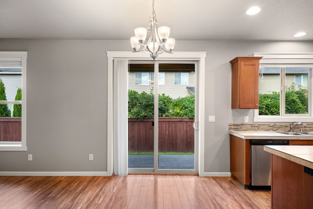 A kitchen with a wooden floor and a chandelier.