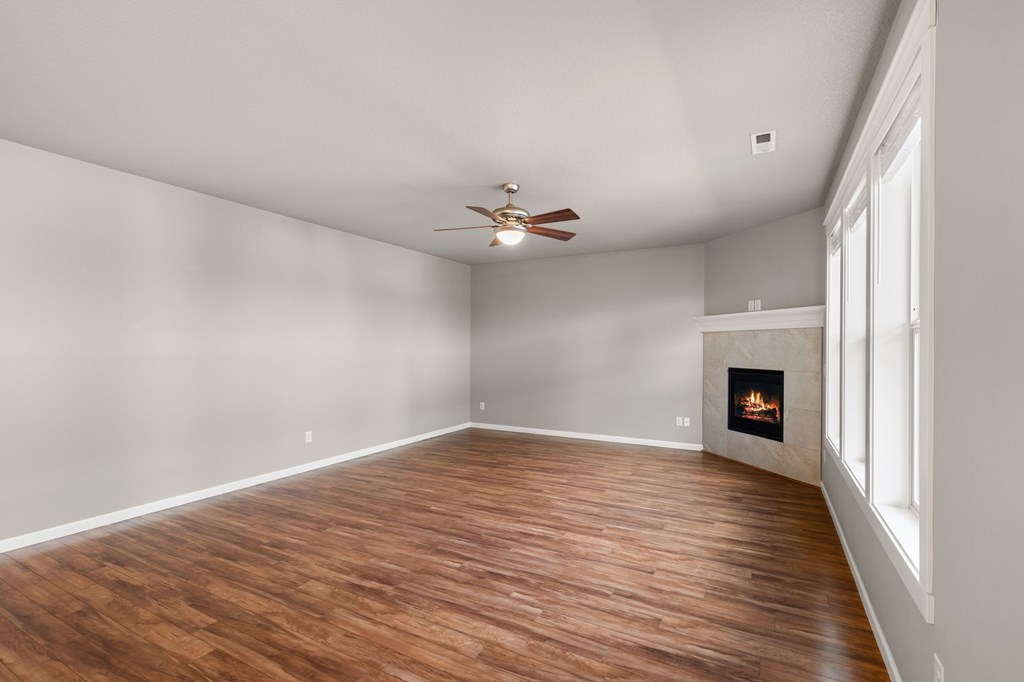 A room with a fireplace and a ceiling fan.