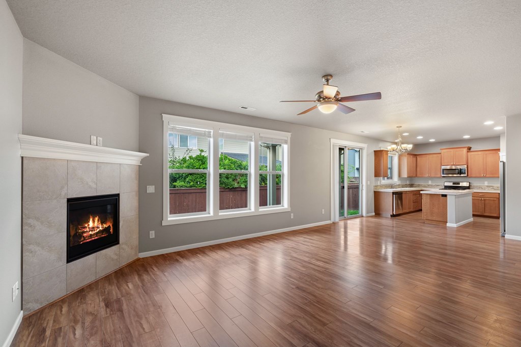 A living room with a fireplace and a ceiling fan.