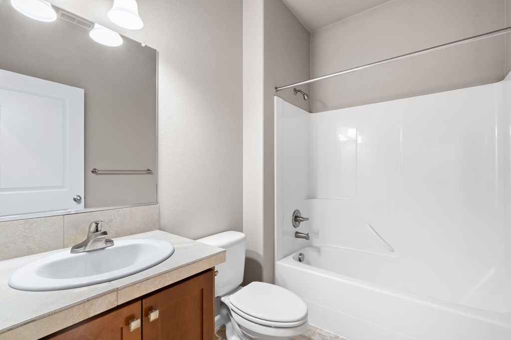 A white bathroom with a sink, toilet, and bathtub.