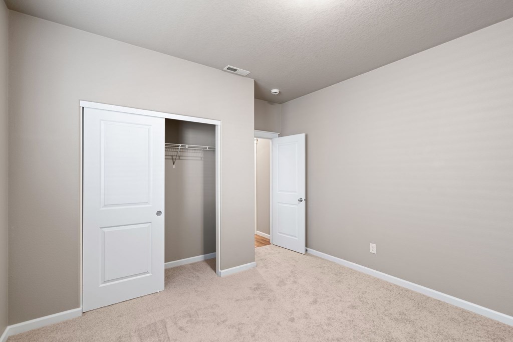 A room with a white door and a carpeted floor.