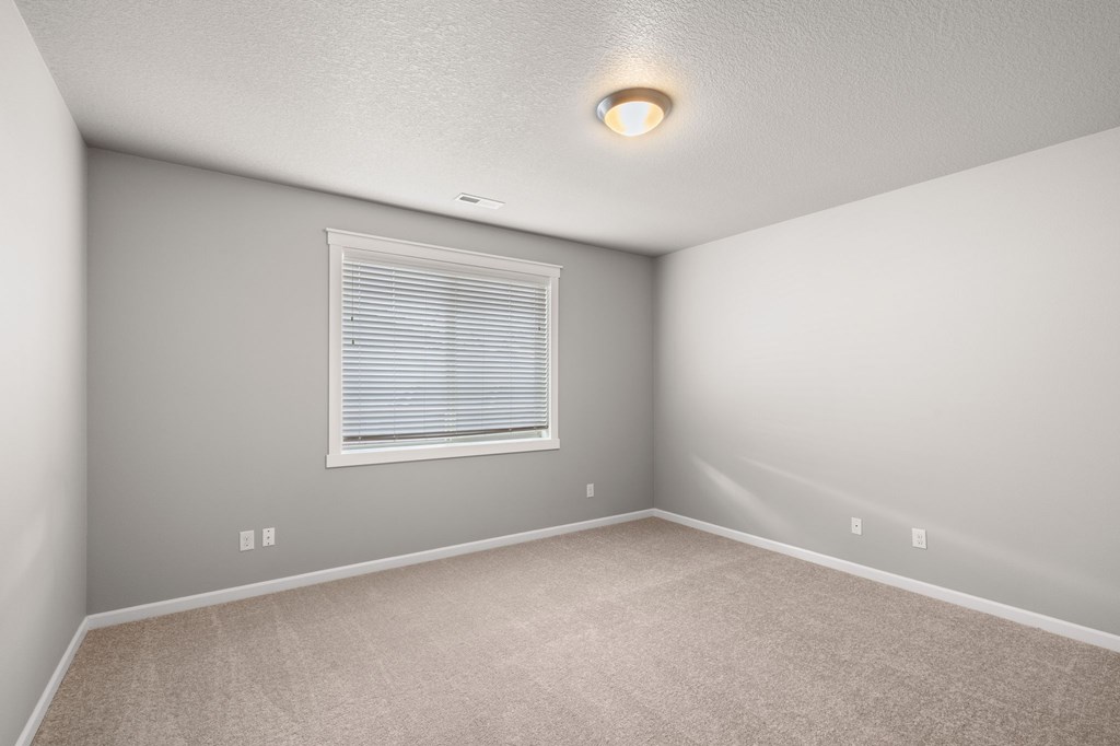 A room with a window and carpeted floor.