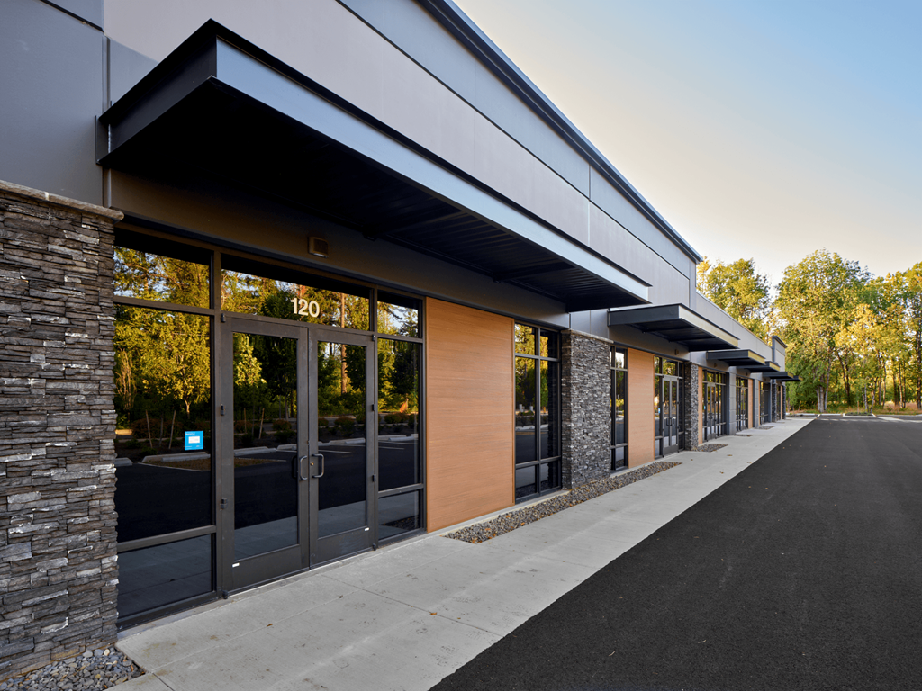 the exterior of a building with glass doors and a sidewalk