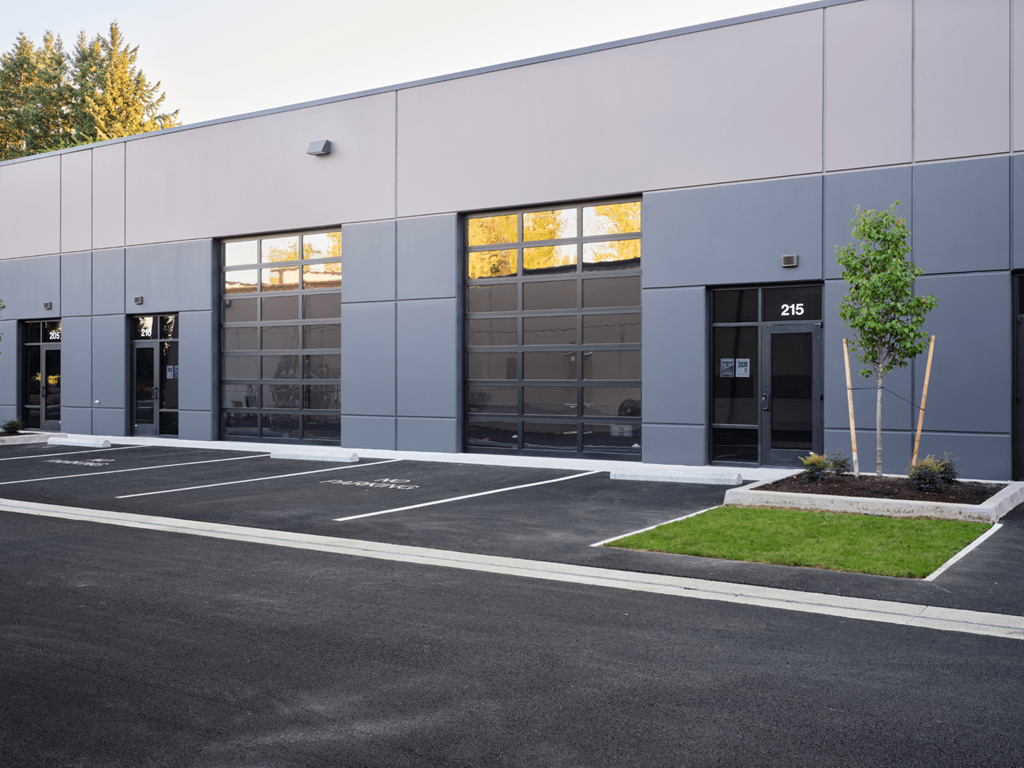 the exterior of a building with glass windows and a parking lot