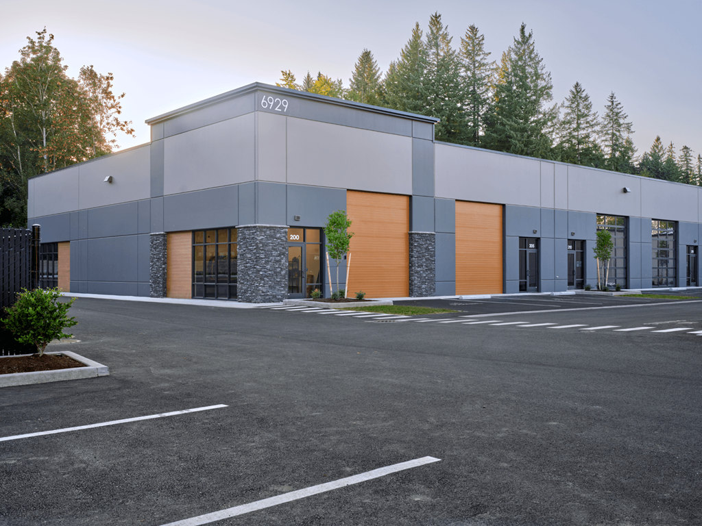 a modern building with a parking lot and trees