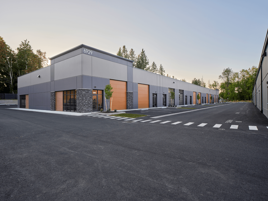 a modern building with orange doors and a parking lot