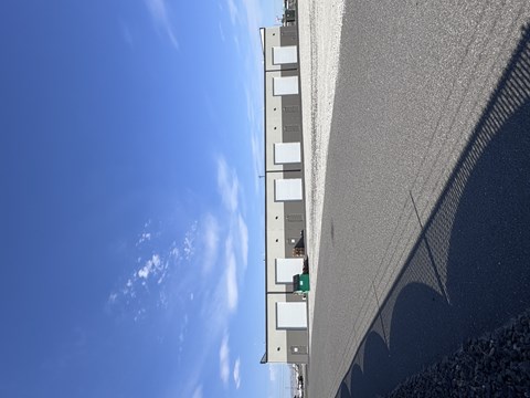 A building with a grey facade and a blue sky in the background.