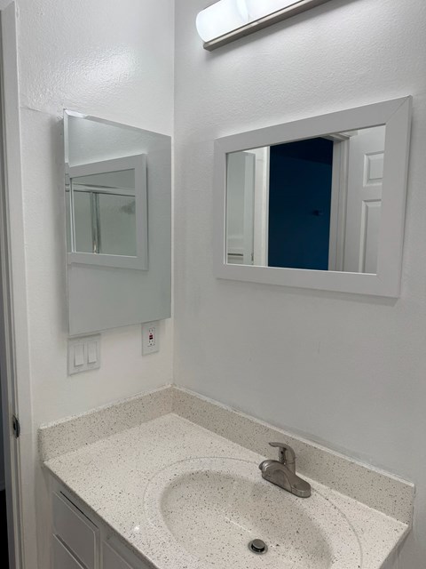 A bathroom with a sink and mirror.