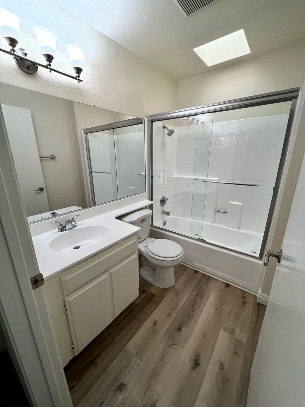 A bathroom with a toilet, sink, and shower.