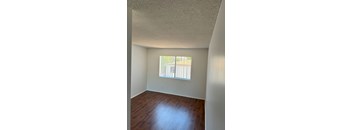A room with a window and wooden floors.