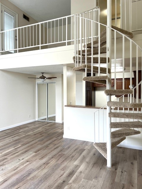 A spiral staircase with a carpeted runner leads up to a second floor.