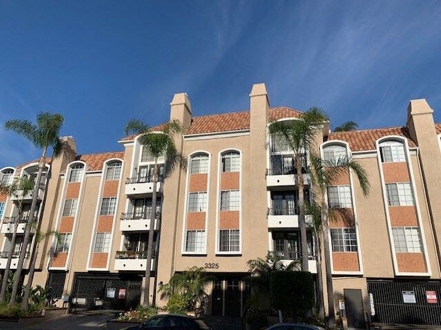 The castle heights apartment building with a balcony and a black gate in front.