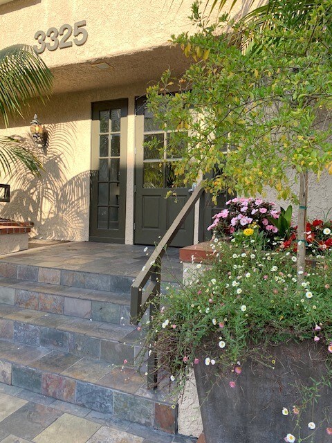 The front entrance to castle heights apartments 3325 with a green door and steps leading up to it.