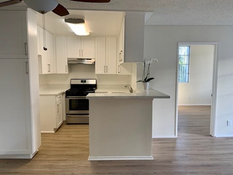 A kitchen with white cabinets and a wooden island.