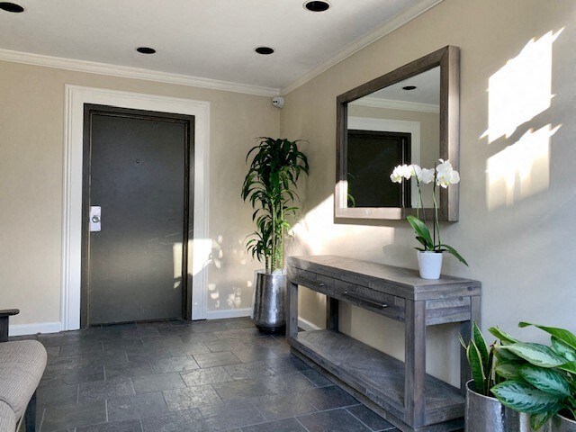 A room with a grey floor and a mirror on the wall.