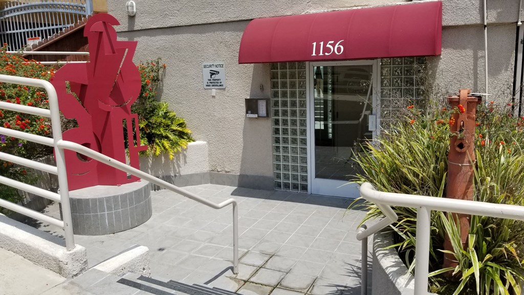 A red sculpture in front of the leasing building and the number 1156.