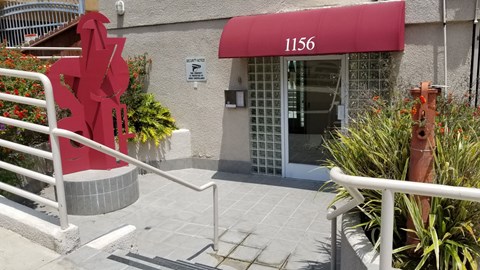 A red sculpture in front of the leasing building and the number 1156.
