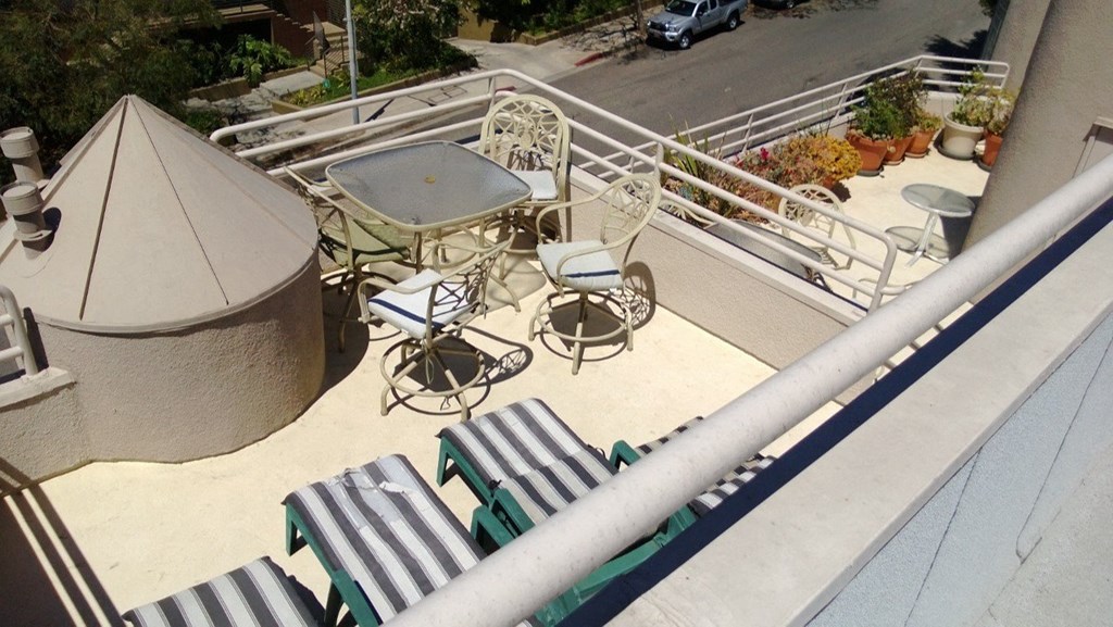 A patio with a table and chairs is seen from above.