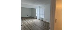 an empty living room with wood floors and a sliding glass door