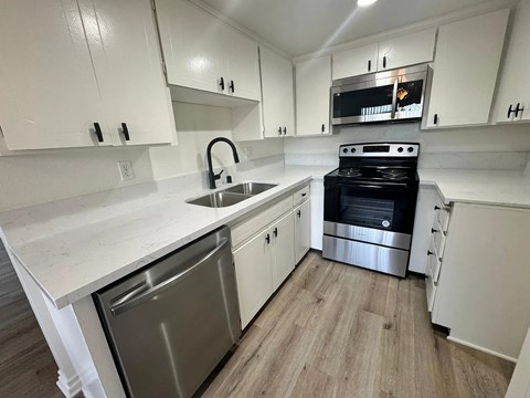 A kitchen with white cabinets and a black oven.