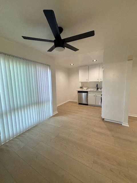 A room with a ceiling fan and a window with blinds.