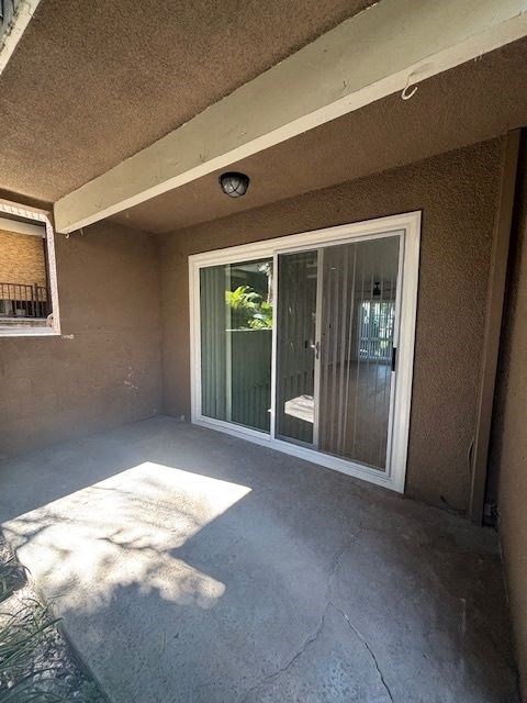 A patio with a sliding glass door and a window.
