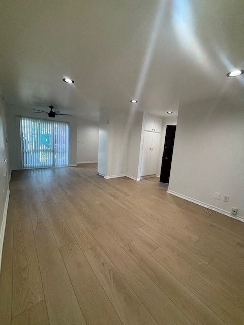 A room with wooden flooring and a ceiling fan.