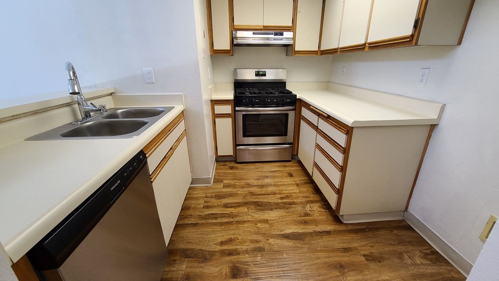 A kitchen with wooden floors and white walls.