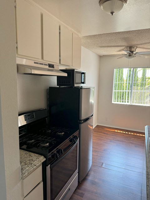 A kitchen with black appliances and white cabinets.
