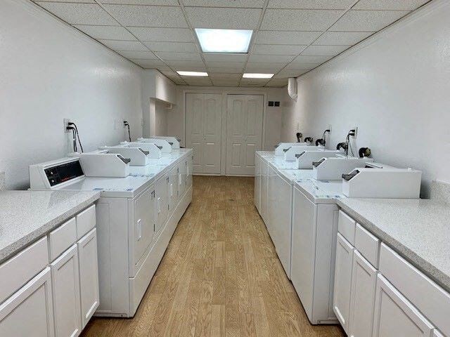 A clean, white-walled public restroom with two sinks on each side.