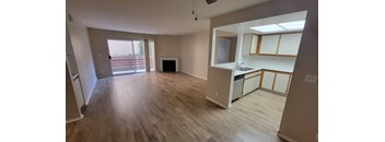 A kitchen area with a sink, cabinets, and a window.