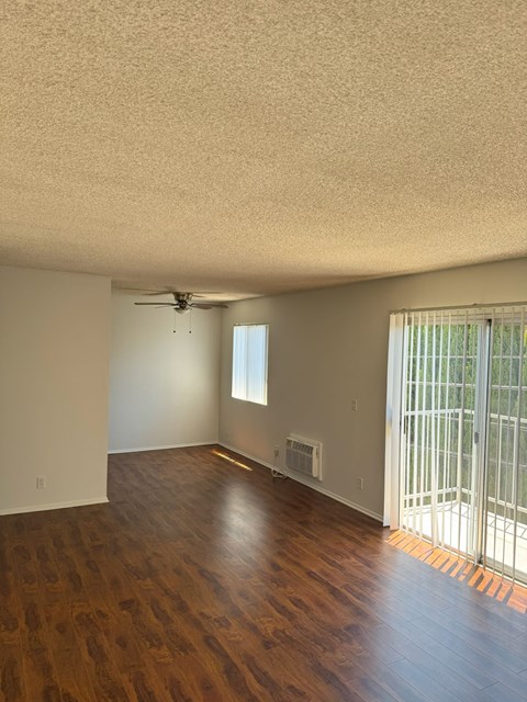 A room with a ceiling fan and a window with blinds.
