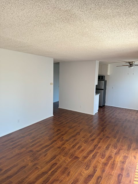 A room with wooden floors and a ceiling fan.