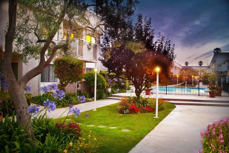 a house with a yard and a pool at night