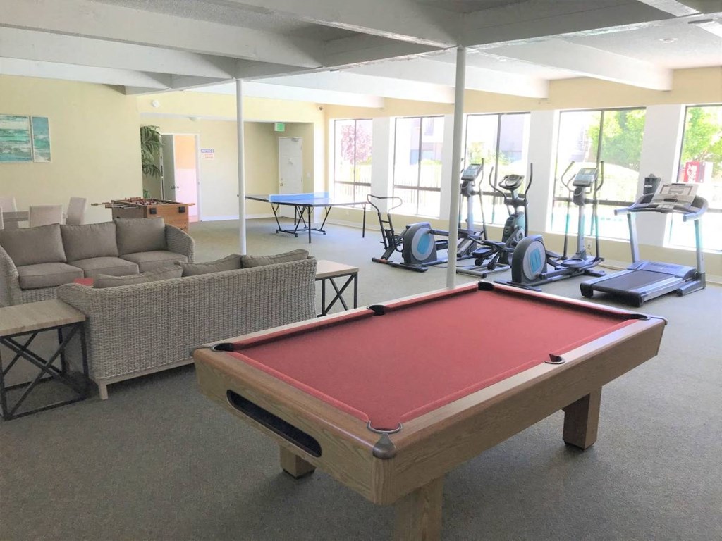 a game room with a pool table in the middle