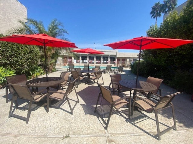 a patio with umbrellas and tables with chairs