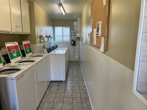 a kitchen with white appliances and a long counter