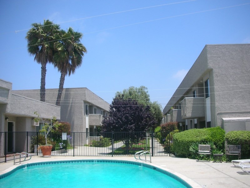 an apartment building with a swimming pool and palm trees